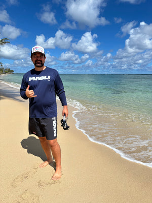 Man standing on the shore with Maoli ocean apparel and a snorkel